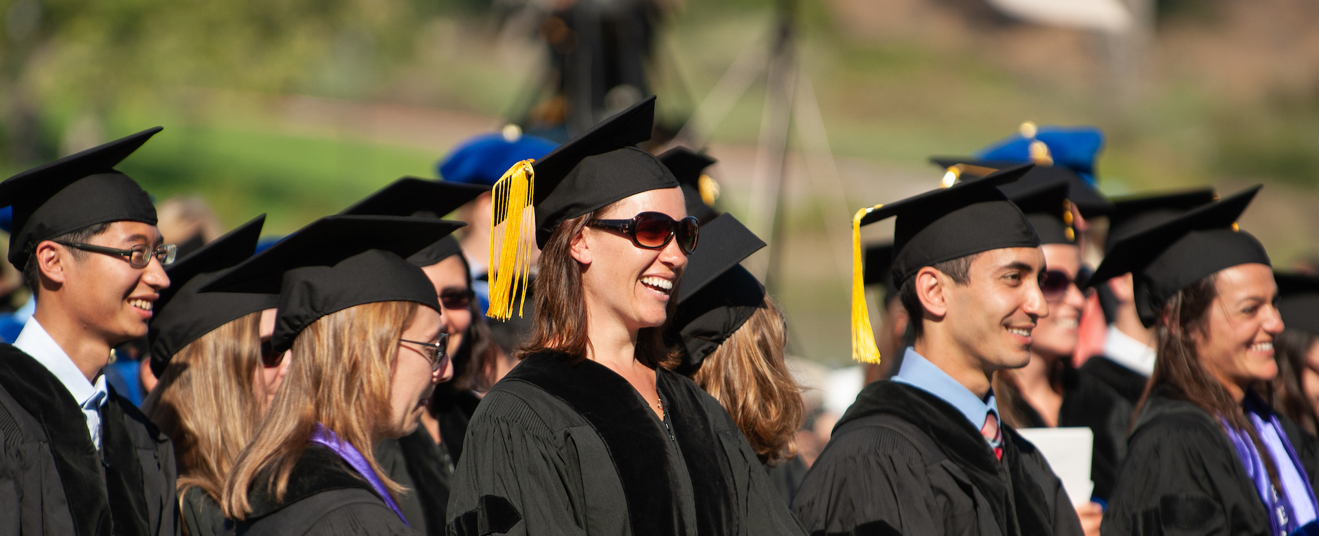 Graduate students standing at commencement with graduation robes and caps