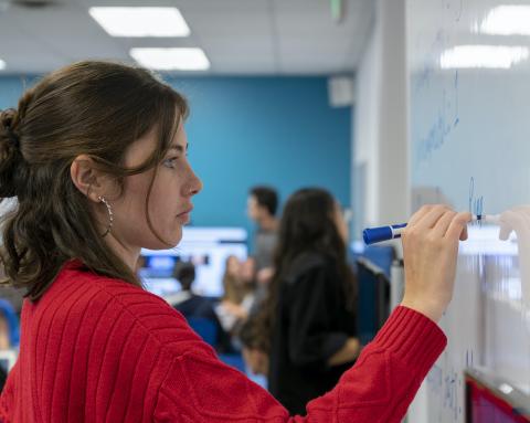 Person writing on whiteboard