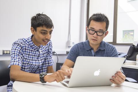 Two international students talking at a desk